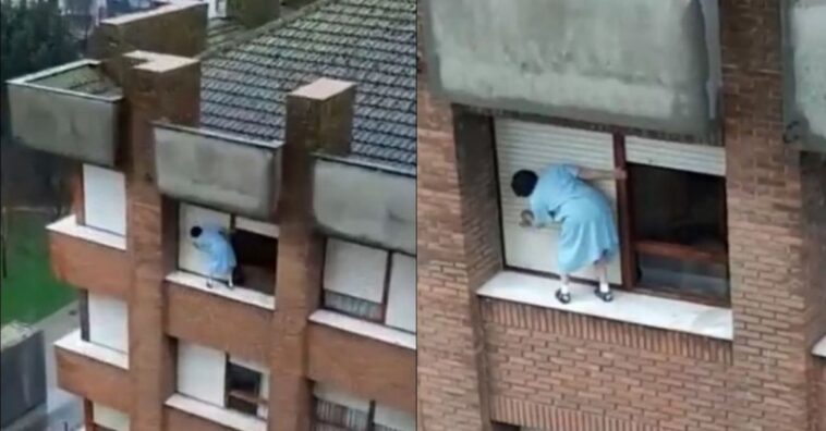 limpia las persianas sobre el alféizar de la ventana en un séptimo piso sin sujeción